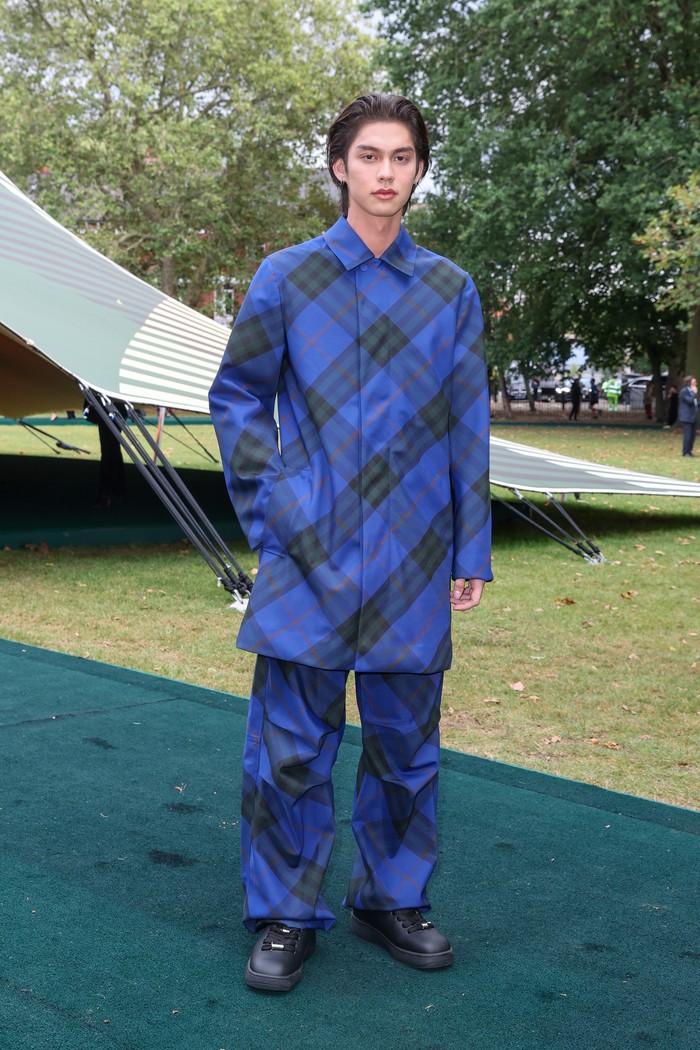 Bright tidak terlewatkan berkat balutan outfit biru plaid khas Burberry. Hanya dengan setelan kemeja, celana panjang oversized, dan hoop earrings silver, sang aktor Thailand langsung mengalihkan pandangan/ Foto: Dave Benett/Getty Images for .../David M. Benett