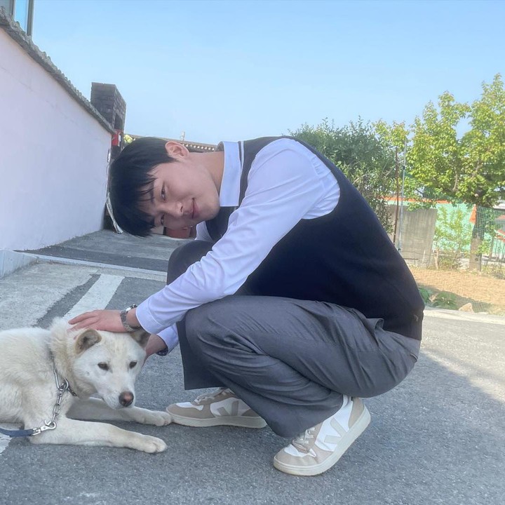 <p>Choi Hyun-wook sedang berpose ke arah kamera sembari mengelus-elus seekor anjing Pungsan milik orang lain. Menggemaskan sekali, ya? (Foto: Instagram @_choiiii__)</p>