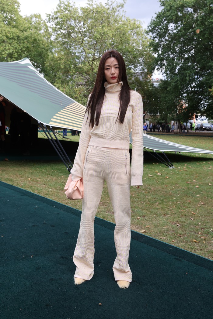 Sekilas tampak seperti outfit atheleisure, tapi setelan yang dikenakan Jun Ji Hyun merupakan rajutan berpotongan klasik, mulai dari kerah tinggi hingga celana flare. Sepatu aksen bulu juga menambah keunikan OOTD monokromatiknya./ Foto: Courtesy of Burberry