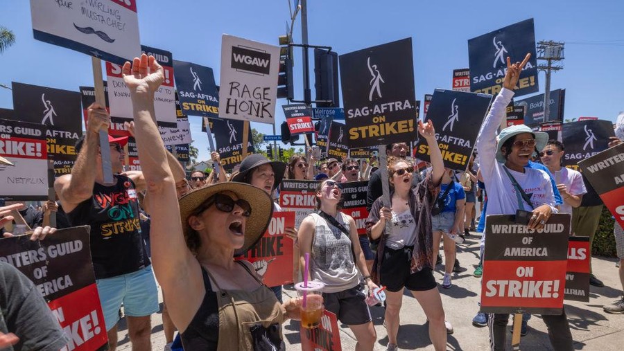 LOS ANGELES, CALIFORNIA - JULY 14: Members of the Hollywood actors SAG-AFTRA union walk a picket line with screenwriters outside of Paramount Studios on Day 2 of the actors' strike on July 14, 2023 in Los Angeles, California. Members of SAG-AFTRA, Hollywood’s largest union which represents actors and other media professionals, joined striking WGA (Writers Guild of America) workers in the first joint walkout against the studios since 1960. The strike could shut down Hollywood productions completely with writers in the third month of their strike against the Hollywood studios.  (Photo by David McNew/Getty Images)