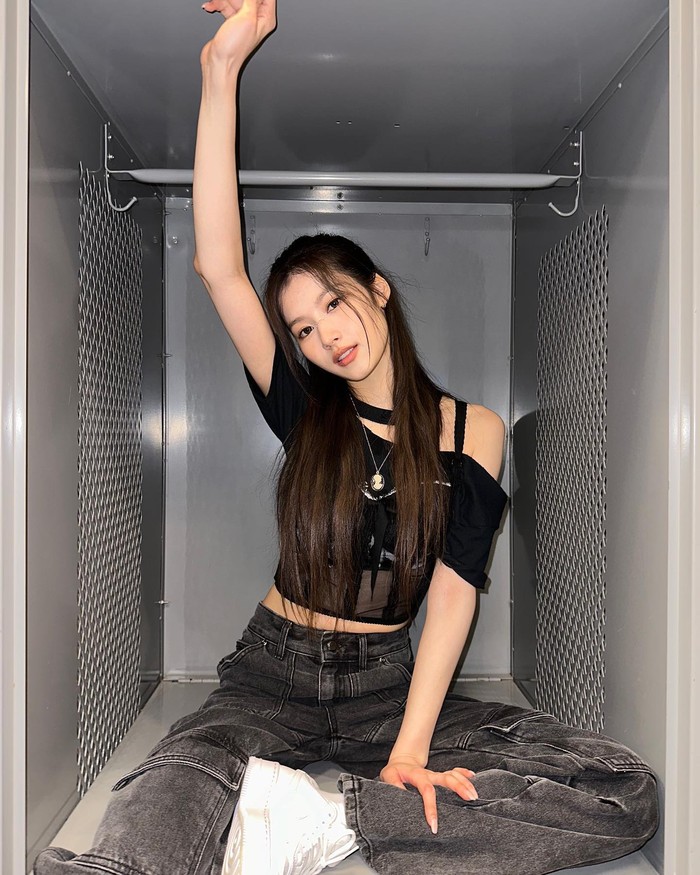 Sana TWICE menawan dengan outfit crop top asimetris berwarna hitam. Untuk lengkapi OOTD-nya, ia memakai jeans cargo yang ciptakan aura swag. Foto : instagram.com/m.by__sana
