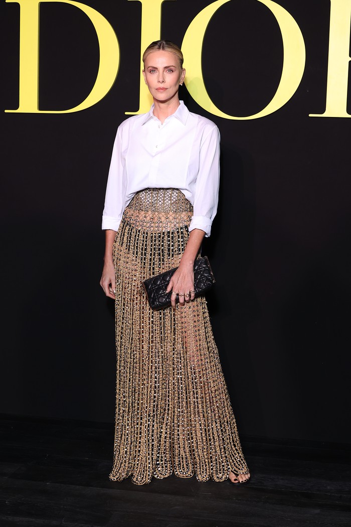Tidak pernah mengecewakan di acara Dior. Charlize Theron mengenakan crochet skirt dan kemeja putih yang membuatnya merasa lebih dari sekadar siap tampil di peragaan busana/ Foto: Corbis via Getty Images/Stephane Cardinale - Corbis