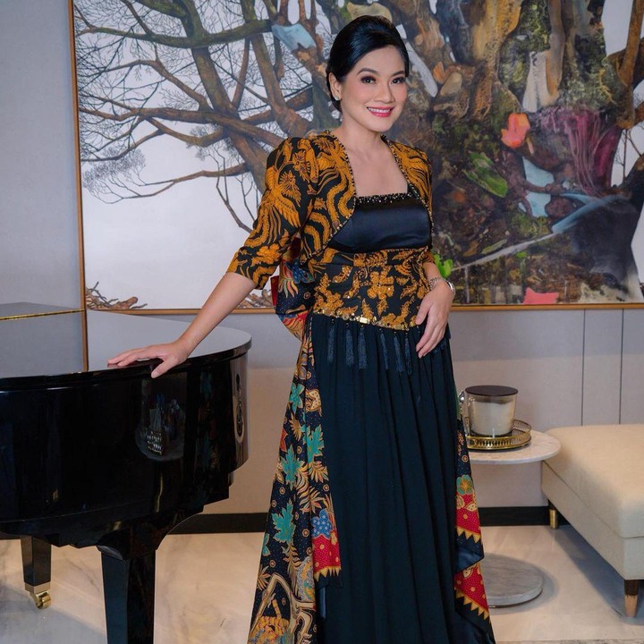 <p>Di Hari Batik tahun ini, Titi Kamal ikut merayakan dengan berpartisipasi dalam Fashion Show Istana Berbatik di Istana Negara. Titi mengenakan gaun batik dengan motif cokelat hitam di bagian atas, dan corak warna kemerahan, hijau, cokelat, dan hitam untuk ekor gaun. Gaun batik yang dikenakan Titi ini dibuat oleh Inne Collection. (Foto: Instagram @titi_kamall)</p>