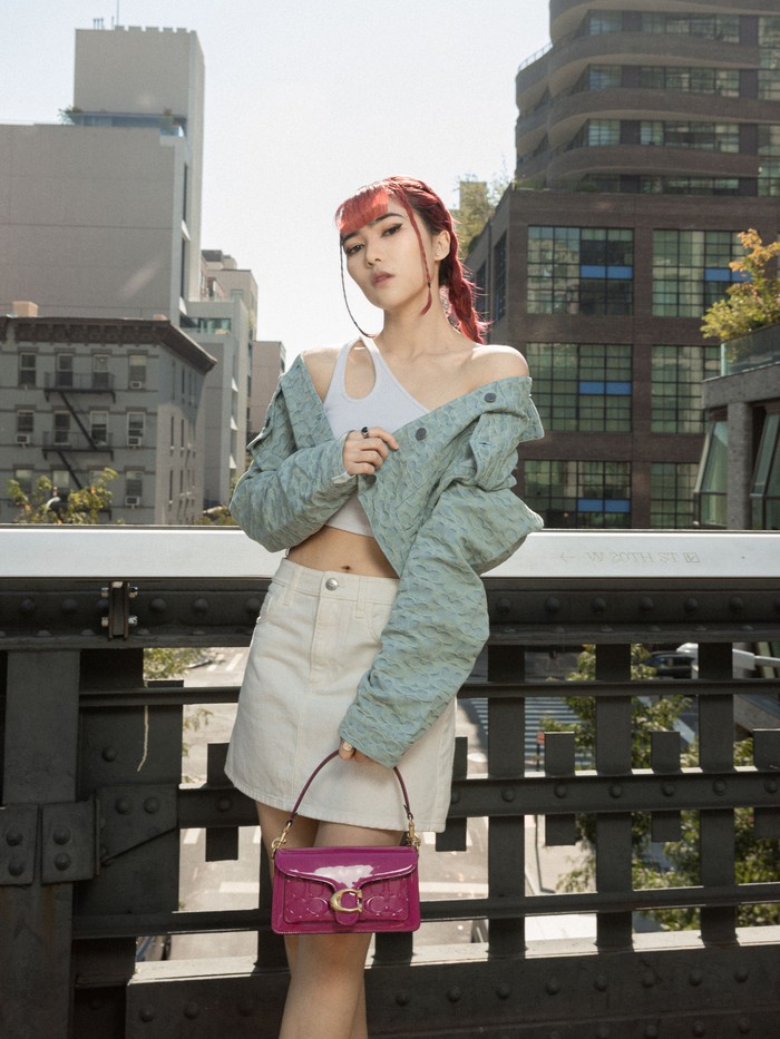 Nuansa yang sama ikut digenggam penampilan Isyana Sarasvati di The High Line. Jacquard denim jacket dari Coach jadi highlight setelah disandingkan dengan rok denim putih. Pulasan warna magenta dari Coach tabby shoulder bag juga memperkuat street style Isyana ini. / Foto: Courtesy of Coach