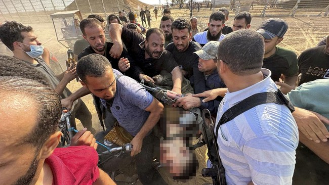Seorang warga Israel, Yoni Asher, menunjukkan sejumlah potret yang memperlihatkan istri dan anaknya diduga diculik oleh militan Palestina, Hamas.