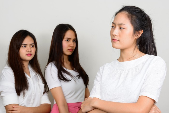Studio shot of young beautiful Asian friends together against white background