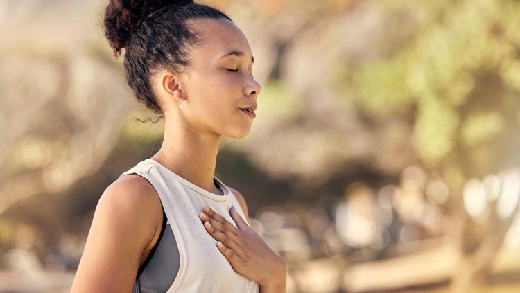 Black woman, breath and hand on chest, for meditation and wellness being peaceful to relax. Bokeh, African American female and lady outdoor, in nature and being calm for breathing exercise and health