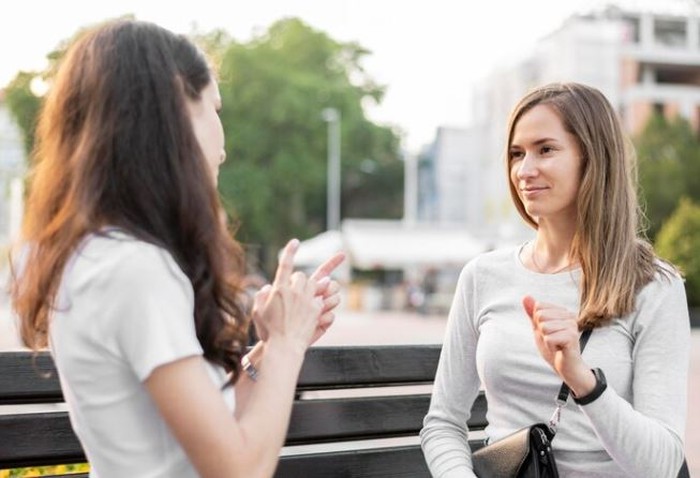 Dua perempuan sedang mengobrol Dua perempuan sedang mengobrol