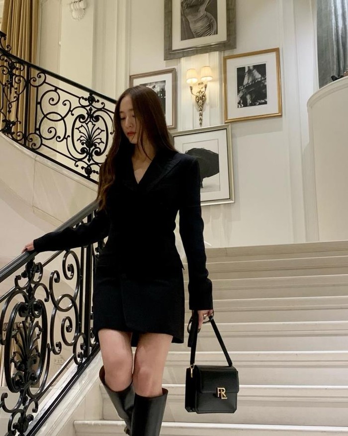 Krystal Jung's black dress exudes a unique and elegant aura.  Its angular shoulders and slim silhouette enhance its elegant charm.  Complete with boots that make it look shining./ Photo: elle.co.kr