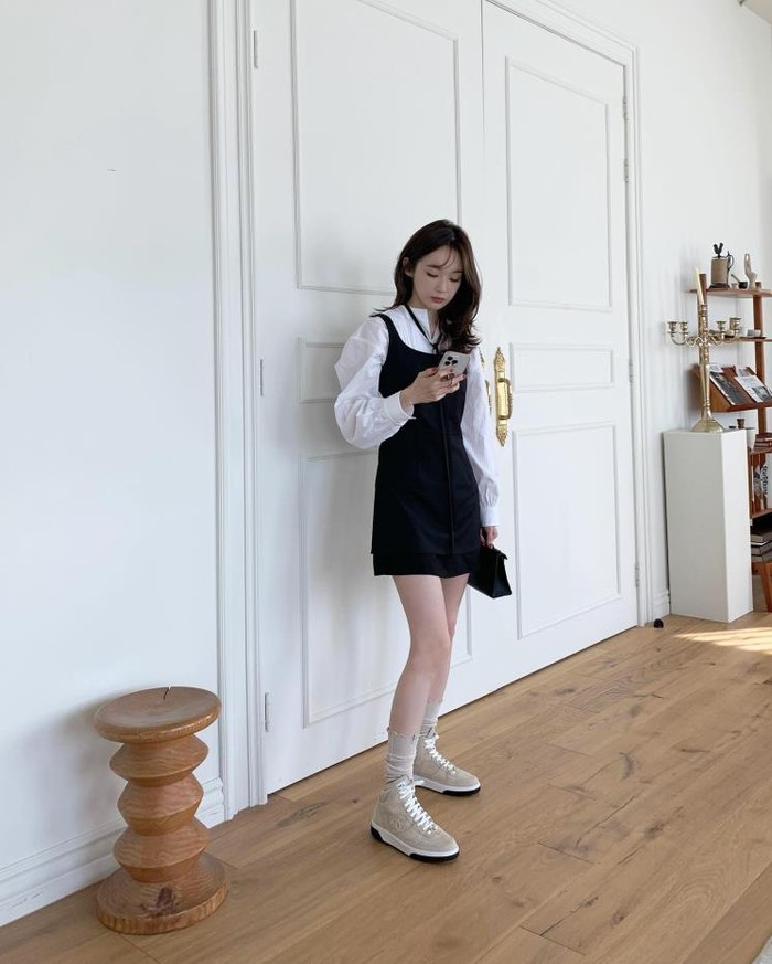 Kang Min Kyung wore a black sleeveless dress combined with a white blouse.  Instead of using Mary Jane shoes or pumps, she gets rid of the monotony by mixing and matching sneakers./ Photo: elle.co.kr