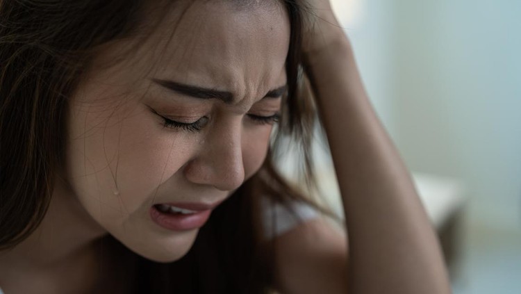 Asian beautiful depression girl crying in tears sit on bed in bedroom. Attractive unhappy young woman feeling sad lonely and upset with life problem and hold tissue on hands in dark night room at home