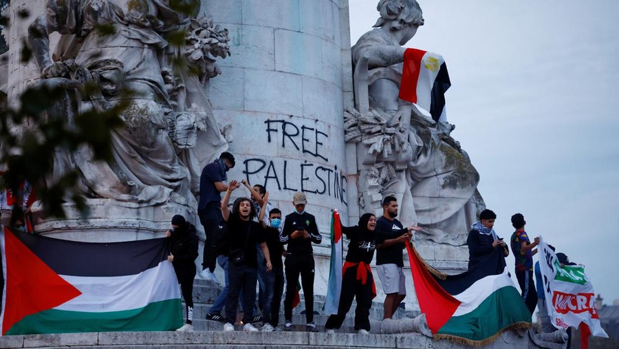 Protestors hold Palestinian flags during an unauthorized demonstration in support of Palestinians, as part of the ongoing conflict between Israel and the Palestinian Islamist group Hamas, at Place de la Republique in Paris as French Interior Minister Gerald Darmanin ordered the systematic banning of pro-Palestinian demonstrations and the arrest of participants within France, October 12, 2023. REUTERS/Sarah Meyssonnier