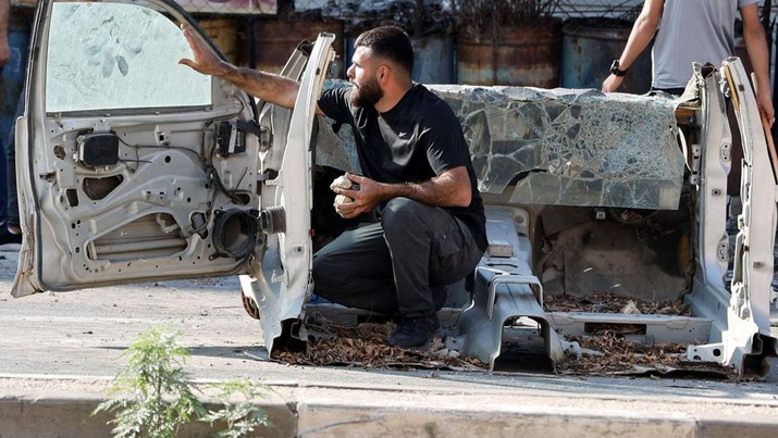 Seorang warga Palestina berlindung saat pasukan Israel menyerang di perbatasan jalur Gaza. (REUTERS/Raneen Sawafta)
