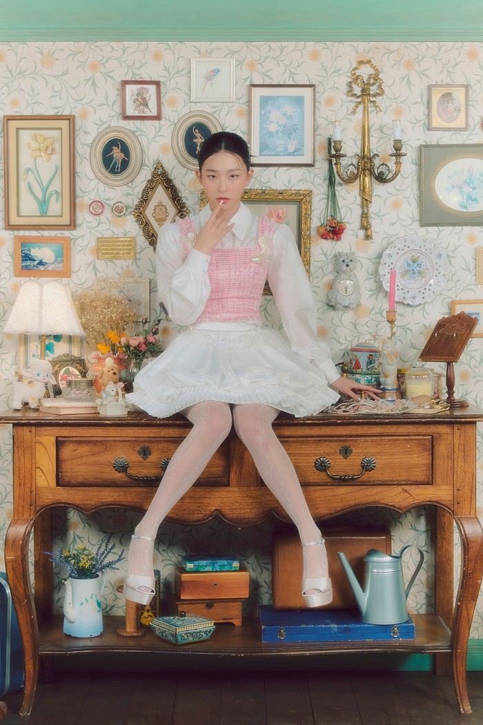 Gaya balletcore yang dipakai Seulgi Red Velvet dalam comeback Feel My Rhythm ini bisa banget kamu tiru, Beauties! Padukan kemeja dan rok tutu putih dengan tank top berwarna pastel untuk penampilan feminin yang anggun./ Foto: Facebook/Red Velvet