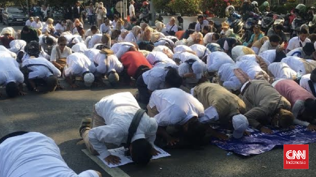 Sekelompok massa melakukan sujud di Patung Kuda, Jakarta Pusat, usai MK mengabulkan gugatan syarat pendaftaran capres-cawapres.
