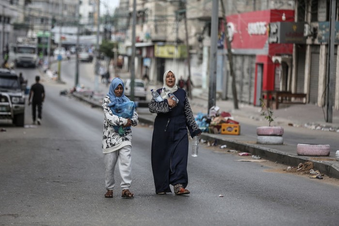 GAZA CITY, GAZA - OCTOBER 17: Palestinian women carry their bottles of water after Israeli authorities have ceased supplying electricity, water and food as Israeli airstrikes continue in Gaza Strip on October 17, 2023. (Photo by Ali Jadallah/Anadolu via Getty Images)