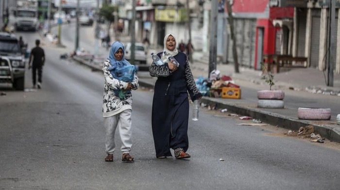 GAZA CITY, GAZA - OCTOBER 17: Palestinian women carry their bottles of water after Israeli authorities have ceased supplying electricity, water and food as Israeli airstrikes continue in Gaza Strip on October 17, 2023. (Photo by Ali Jadallah/Anadolu via Getty Images)