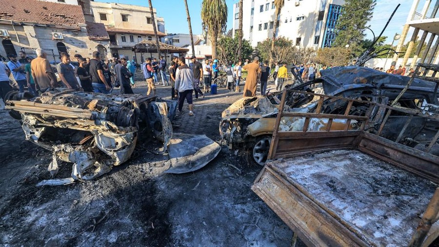 Warga memeriksa puing-puing di luar Rumah Sakit Arab Al-Ahli Arab di Jalur Gaza usai pengeboman terjadi People search through debris outside the site of the Ahli Arab hospital in central Gaza on October 18, 2023 in the aftermath of an overnight blast there. A blast ripped through a hospital in war-torn Gaza killing hundreds of people late on October 17, sparking global condemnation and angry protests around the Muslim world. Spokesman Hagari told a press briefing that at the time of the incident, the Israeli army was not conducting air operations near the hospital and the rockets that hit the building did not match theirs. (Photo by MAHMUD HAMS / AFP)