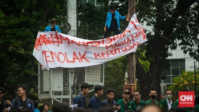 Massa mahasiswa yang menggelar demonstrasi memasang spanduk penolakan terhadap putusan Mahkamah Konstitusi soal syarat capres-cawapres.