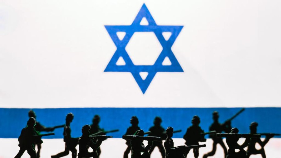 EDMONTON, CANADA - OCTOBER 13, 2023:
Illustrative photo of small figurines representing Israel Defense Forces in front of the Israeli flag, on October 13, 2023, in Edmonton, Alberta, Canada.
On October 7, 2023, Hamas infiltrated Israel, resulting in horrific violence. In response, Israel is preparing a major ground offensive to eliminate Hamas and launched airstrikes that tragically killed over 1,900 people, displacing nearly half a million Palestinians. The IDF aims to overthrow Hamas's rule in Gaza (Photo by Artur Widak/NurPhoto via Getty Images)