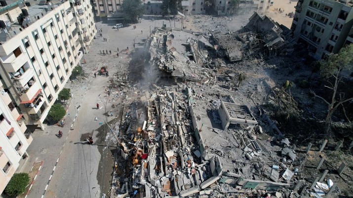 ISRAEL-PALESTINIANS/ Palestinians gather around residential buildings destroyed in Israeli strikes in Zahra City, amid the ongoing conflict between Israel and Palestinian Islamist group Hamas, in southern Gaza City, October 19, 2023. REUTERS/Shadi Tabatibi