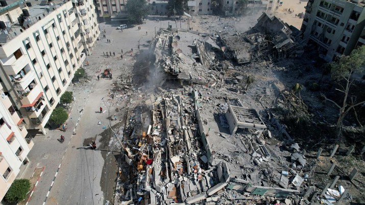 Palestinians gather around residential buildings destroyed in Israeli strikes in Zahra City, amid the ongoing conflict between Israel and Palestinian Islamist group Hamas, in southern Gaza City, October 19, 2023. REUTERS/Shadi Tabatibi