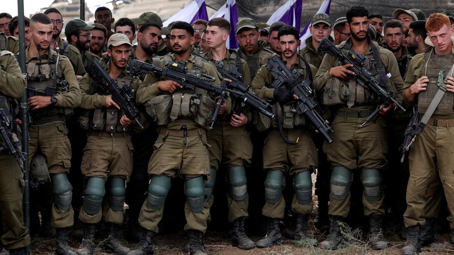 Israeli soldiers listen to Israel's Defence Minister Yoav Gallant as he meets them in a field near Israel's border with the Gaza Strip, in southern Israel October 19, 2023. REUTERS/Ronen Zvulun     TPX IMAGES OF THE DAY