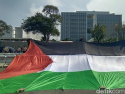 Massa Aksi Bentangkan Bendera Palestina Raksasa di Depan Kedubes AS