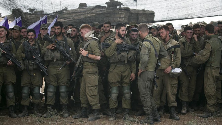 SDEROT, ISRAEL - OCTOBER 19: Israeli soldiers stand as they wait for a meeting with Israeli Minister of Defence Yoav Gallant on the Israeli border with the Gaza Strip on October 19, 2023 in Sderot, Israel. As Israel prepares to invade the Gaza Strip in its campaign to vanquish Hamas, the Palestinian militant group that launched a deadly attack in southern Israel on October 7th, worries are growing of a wider war with multiple fronts, including at the country's northern border with Lebanon. Countries have scrambled to evacuate their citizens from Israel, and Israel has begun relocating residents some communities on its northern border. Meanwhile, hundreds of thousands of residents of northern Gaza have fled to the southern part of the territory, following Israel's vow to launch a ground invasion.  (Photo by Amir Levy/Getty Images)
