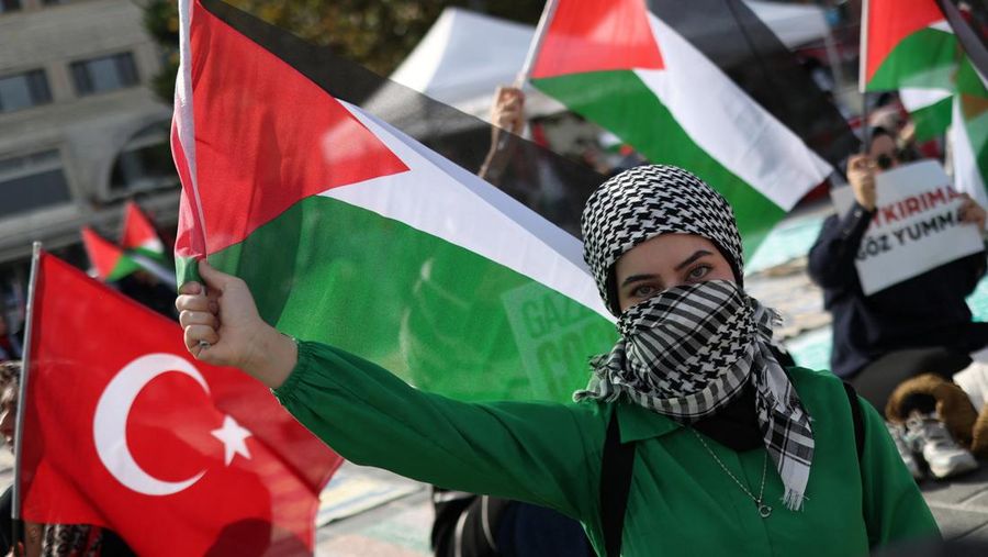 Seroang perempuan membawa bendera Palestina saat melakukan unjuk rasa di Istanbul, Turki, Minggu (22/10/20223). (REUTERS/Murad Sezer)