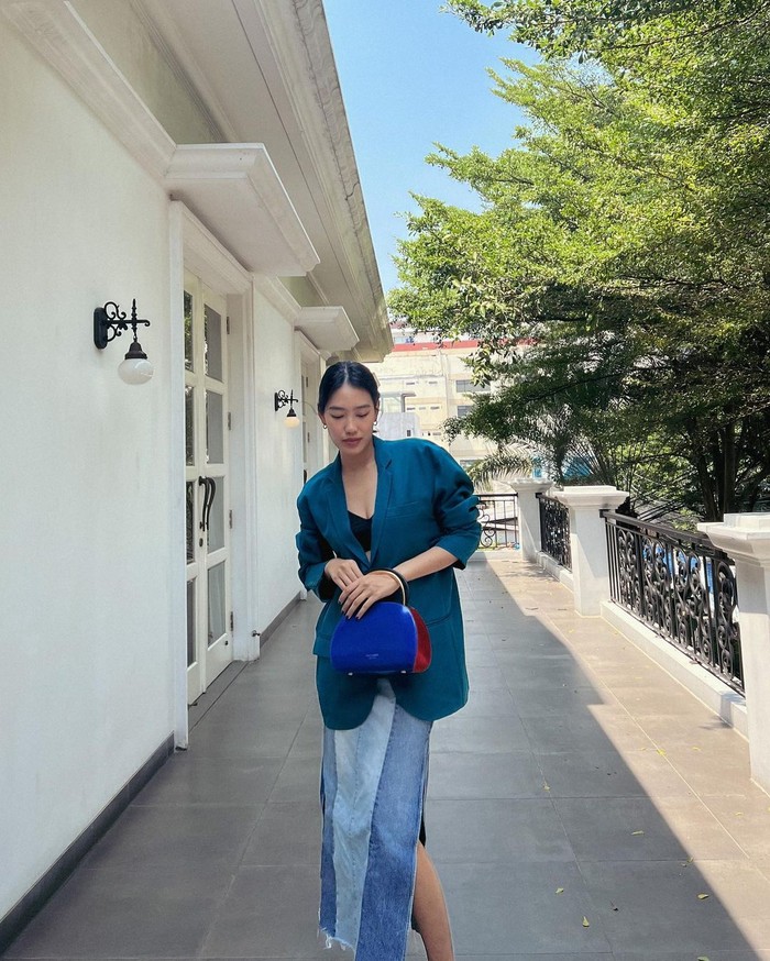 Memusatkan playful look pada tas, Alika Islamadina cukup mengombinasi oversized blazer rona pine green dengan rok maxi denim two-toned, menyesuaikan tas Expo Colorblocked Top-Handle Satchel-nya. / Foto: Courtesy of Kate Spade