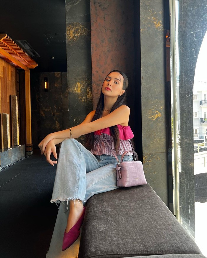 Penampilan kekinian dengan warna fuchsia mencolok akan cocok buat keseharian lewat mix-and-match tepat. Seperti yang diperlihatkan Beby Tsabina, misalnya. Atasan strapless yang vibrant dipilih senada dengan tas Kate Spade Knott Croc-Embossed Mini Crossbody Tote, serta celana jeans yang berkesan laidback./ Foto: Courtesy of Kate Spade