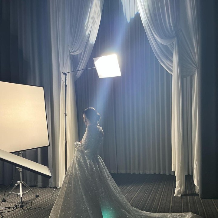 <p>Dengan pencahayaan yang minim, Bae Suzy sedikit membelakangi kamera, memamerkan pesona gaun pengantinnya yang meskipun tertutup bayangan, masih tampak megah. Dari belakang saja, kecantikannya masih sangat terasa ya, Bunda? (Foto: Instagram @skuuksky)</p>