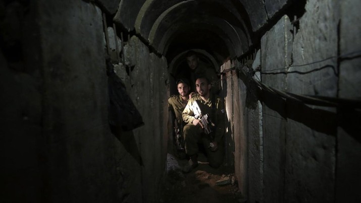 FILE - Israeli soldiers walk through a tunnel discovered near the Israel-Gaza border Sunday, Oct. 13, 2013. An extensive labyrinth of tunnels built by Hamas stretches across the dense neighborhoods of the Gaza Strip, hiding militants, their missile arsenal and the over 200 hostages they now hold after an unprecedented Oct. 7, 2023, attack on Israel. (AP Photo/Tsafrir Abayov, File)