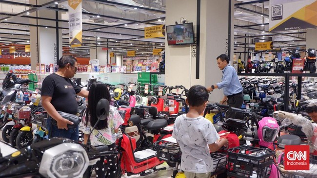 Pengunjung Transmart Kota Kasablanka 'melirik' deretan sepeda listrik yang dijual dengan diskon gede-gedean pada Transmart Full Day Sale, Minggu (29/10).