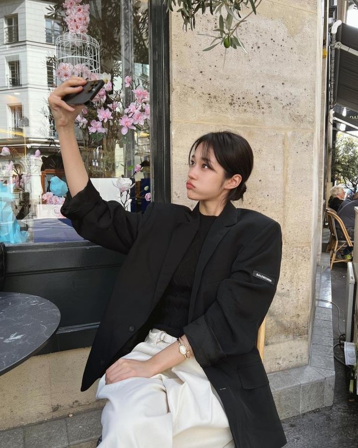 Roh Yoon Seo mengenakan blazer hitam dengan tampil casual dan anggun. Ia memadukan celana putih dan inner hitam ke dalam outfit-nya. Dilengkapi tas bahu atau tas jinjing pasti cocok untuk tampilan kerja, bukan? / Foto: elle.co.kr