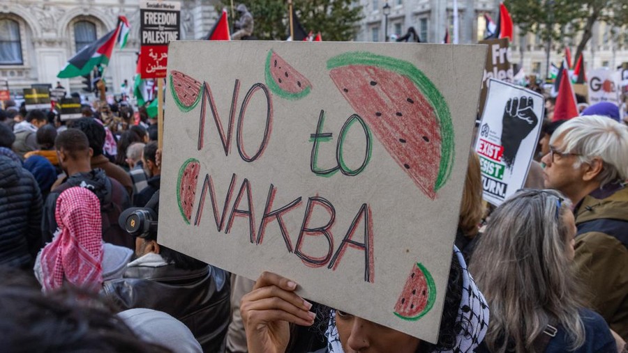 A pro-Palestinian demonstrator holds a sign reading 'No to Nakba' during a rally outside Downing Street in support of the Palestinian population of Gaza on 14th October 2023 in London, United Kingdom. The watermelon, in the colours of the Palestinian flag, is a symbol of resistance in occupied Palestine. Large Palestinian solidarity rallies have been held throughout the UK following Israel's retaliatory attacks on Gaza despite a warning from UK Home Secretary Suella Braverman that waving Palestinian flags or chanting popular slogans in support of Palestine may constitute public order offences. (photo by Mark Kerrison/In Pictures via Getty Images)