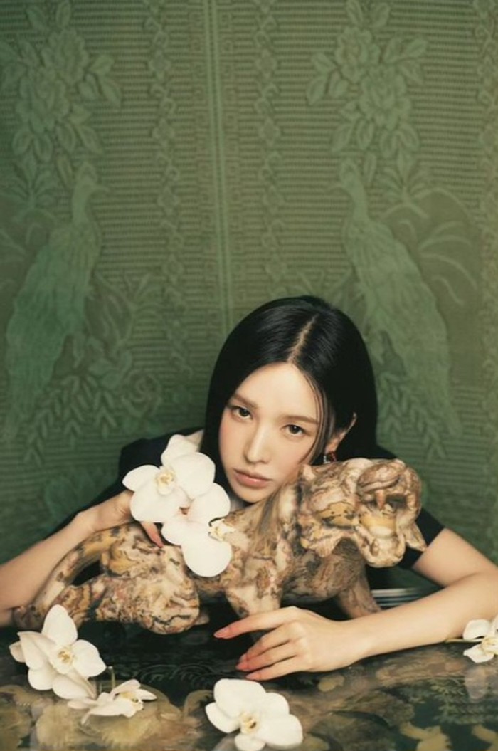 Tampil tanpa poni, Wendi semakin cantik dan anggun. Tatapan lurusnya ke kamera, serta ornamen bunga dan patung harimau membuat kesan misterius semakin menonjol/Foto: instagram.com/redvelvet.smtown