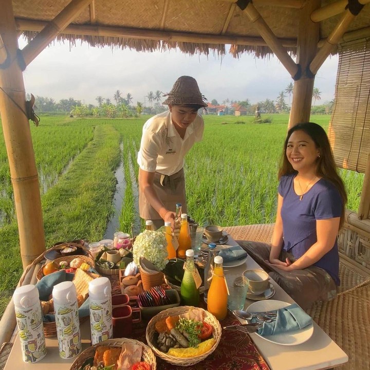 <p>Dalam salah satu foto, istri Baskara Mahendra Putra ini tampak sedang menyantap sarapan di tepi sawah. Sebagai vegetarian, Sherina terlihat hanya menyantap makanan berbahan dasar sayuran dan buah-buahan. (Foto: Instagram @sherinamunaf)</p>