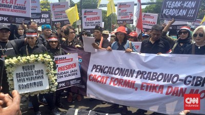 Massa beratribut serba hitam berdemonstrasi di depan kantor KPU jelang penetapan capres-cawapres. Mereka mengkritik proses pencalonan Gibran.