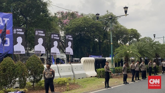 Spanduk dengan siluet cawapres Gibran Rakabuming putra Jokowi disertai tagar #Pilpres1Putaran terpampang di depan kantor KPU jelang pengundian nomor urut.
