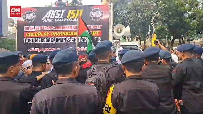 Massa aksi demonstrasi tolak konser Coldplay menyoraki orang-orang yang masuk ke dalam kompleks Gelora Bung Karno (GBK) Jakarta.
