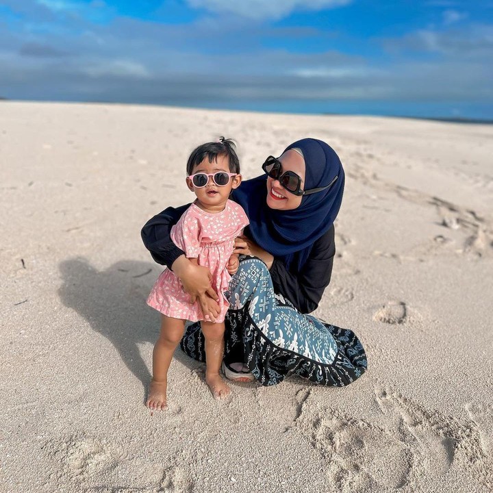 <p>Moana sendiri sangat nyaman saat bermain di pantai bersama sang Bunda. Kakinya bahkan terus menginjak pasir pantai yang berwarna putih. (Foto: Instagram: @riaricis1795)</p>