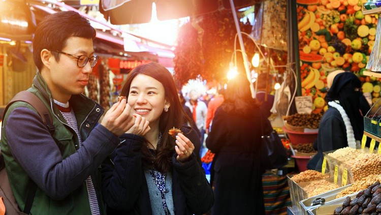 Sweet Korean couple Eating delicious medjool dates eat bazaar Istanbul.