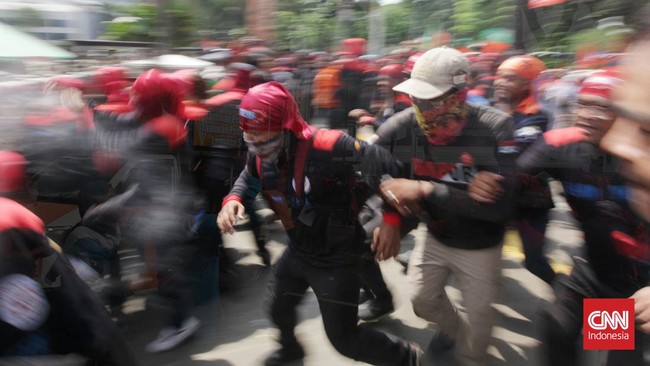 Massa buruh saling dorong dengan petugas kepolisian saat melakukan unjuk rasa di Kawasan MM 2100, Cikarang Barat, Kabupaten Bekasi.