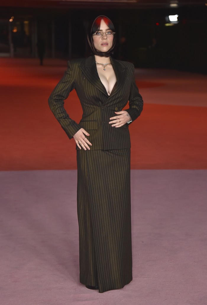Pinstripes aren't just for office wear.  Billie Eilish proves that this outfit from Jean Paul Gaultier is suitable for a red carpet look with sexy styling/ Photo: Jordan Strauss/Invision/AP/Jordan Strauss