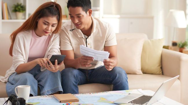 Pengguna mencatat pengeluaran di ponsel saat liburan