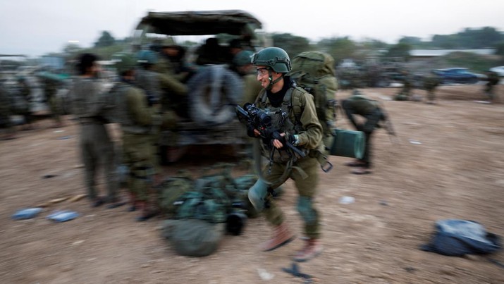 Seorang tentara Israel berjalan dengan membawa senjata, di tengah konflik yang sedang berlangsung antara Israel dan kelompok Islam Palestina Hamas, dekat perbatasan Israel dengan Gaza, di Israel selatan, 4 Desember 2023. Seorang tentara Israel berjalan dengan membawa senjata, di tengah konflik yang sedang berlangsung antara Israel dan kelompok Islam Palestina Hamas, dekat perbatasan Israel dengan Gaza, di Israel selatan, 4 Desember 2023. (REUTERS/Amir Cohen)