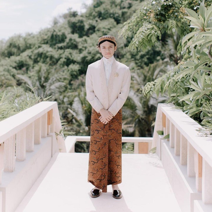 <p>Noah terlihat tampan mengenakan beskap warna nude dengan blankon. Tampilannya semakin sempurna degan kain batik cokelat dan sepatu warna hitam. (Foto: Instagram: @itsmebcl)</p>