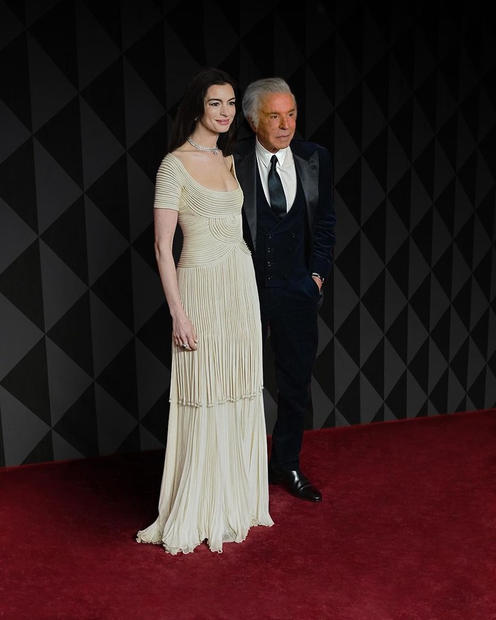 Anne Hathaway hadir bersama Giancarlo Giammetti dalam penampilan bak dewi. Gaun vintage Valentino koleksi Spring/Summer 1993 rona cream dengan detail pleats menjadi pilihannya/ Foto: Instagram.com/maisonvalentino